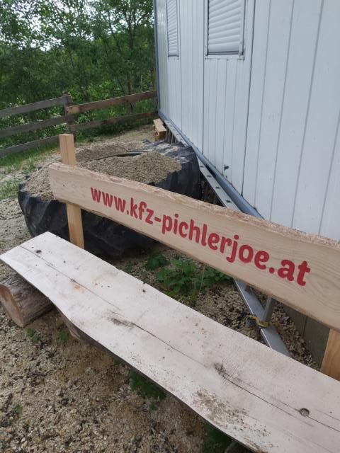 Gemütliche Holzbank mit Internetseite www.kfz-pichlerjoe.at geschrieben